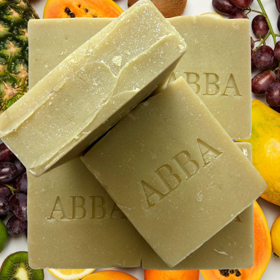 Tres barras rectangulares de jabón de la marca ABBA apiladas, con el nombre de la marca grabado en la superficie. El jabón es de color verde oliva claro.